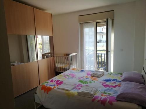 Un dormitorio con una cama con una manta de flores. en Casa MaryGiò, en San Giovanni Teatino
