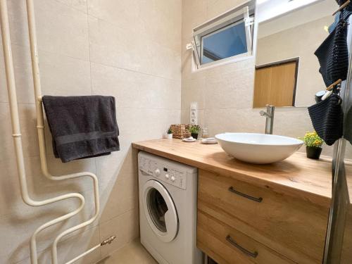 a bathroom with a sink and a washing machine at Cozy room near the city centre in Košice