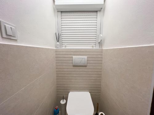 a bathroom with a toilet and a window in it at Cozy room near the city centre in Košice