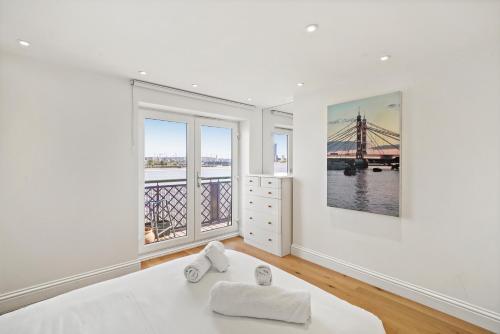 a white room with a bed and two windows at Monthly Stays! 2 Bed Stunning Riverside Apartment in London