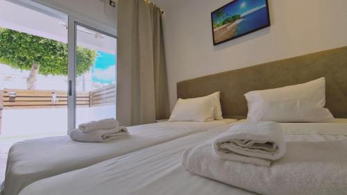 a bedroom with two beds with towels on them at STAY Napa Velvet Apartment in Ayia Napa