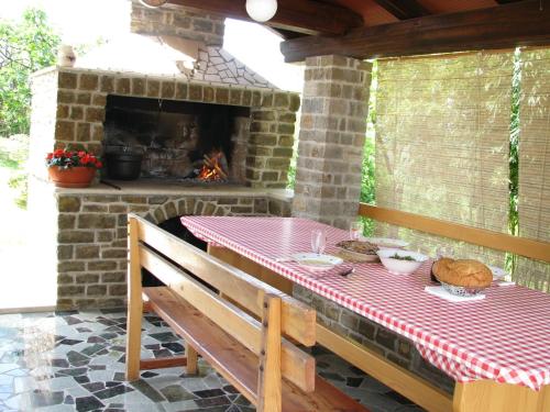 a table and bench on a patio with a fireplace at Guest House Nena in Motovun