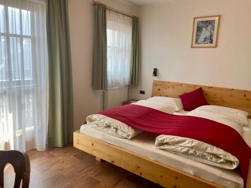 a bedroom with a large bed with a wooden headboard at Da Kathi in San Candido