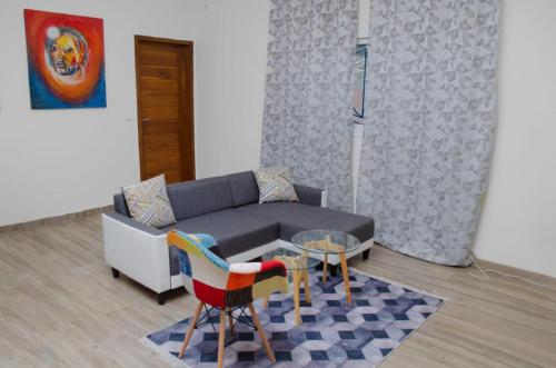 a living room with a couch and a table and chairs at Residence Eliz in Kabrousse