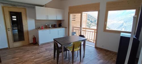 eine Küche mit einem Tisch und Stühlen im Zimmer in der Unterkunft La Reine-des-prés in Vernamiège