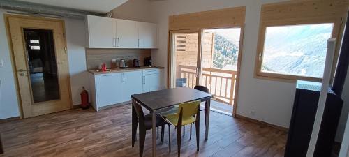 a kitchen with a table and chairs in a room at La Reine-des-prés in Vernamiège