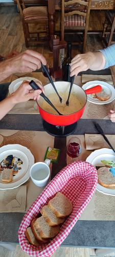 a table with a bowl of soup and a bowl of bread at La Reine-des-prés in Vernamiège