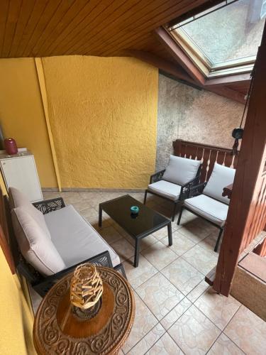 un patio avec des chaises et une table et un puits de lumière dans l'établissement Colmar charmant logement, à Colmar