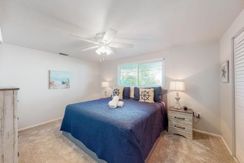 a bedroom with a blue bed with a ceiling fan at South Bay Inn 4 in Anna Maria