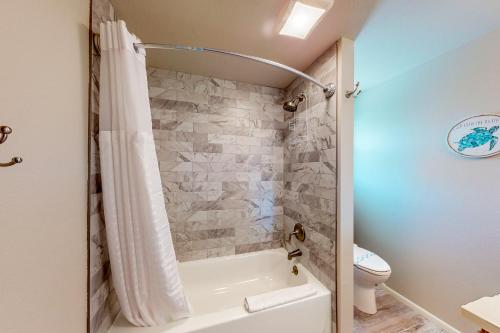 a bathroom with a white tub and a toilet at South Bay Inn 4 in Anna Maria
