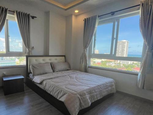 a bedroom with a bed and windows with a view at Ngọc Duyên Homestay- Central Vung Tau, near Lotte Mart in Vung Tau
