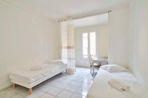 une chambre avec deux lits et une fenêtre dans l'établissement Nidusudest - Spacieux appartement, à Nice
