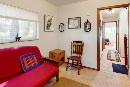 a living room with a red couch and a chair at Zen Amongst the Trees in Truckee