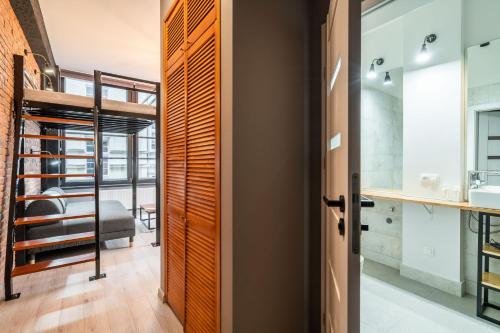 um quarto com uma porta que leva a uma casa de banho com um lavatório em Graffiti Apartments em Breslávia