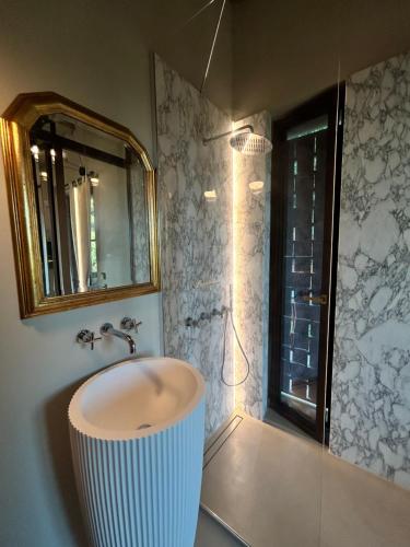 a bathroom with a sink and a shower with a mirror at Tenuta Zamparina in Montignoso