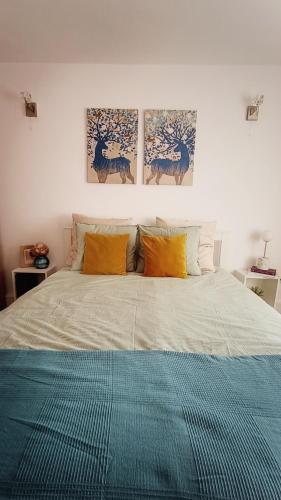 a bedroom with a bed with three paintings on the wall at Central View Calimanesti in Călimăneşti