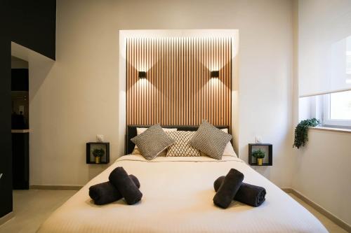 a bedroom with a large bed with two pillows at La Golden Suite in Cambrai