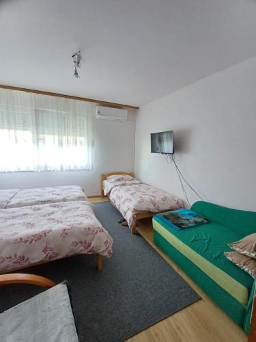 a room with two beds and a couch in it at Apartments Lela in Bihać