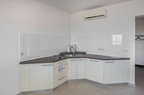 a kitchen with white cabinets and a sink at Villa Montana - Apartment Panorama 1 with beautiful sea view in Veprinac