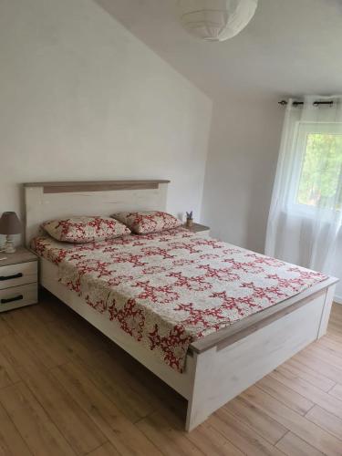 ein Schlafzimmer mit einem Bett mit roter Bettdecke und einem Fenster in der Unterkunft Sunny Valley in Bar