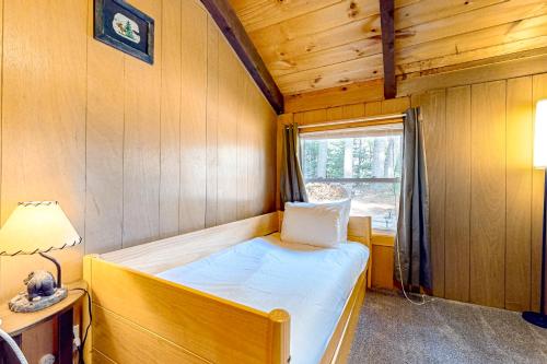 a small bedroom with a bed and a window at White Mountain Grove in Conway
