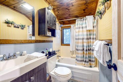uma casa de banho com um lavatório, um WC e uma banheira em White Mountain Grove em Conway