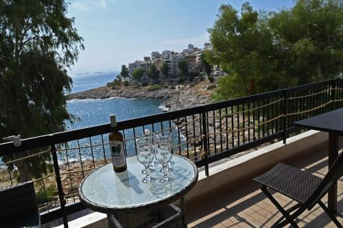 a table with a bottle of wine and glasses on a balcony at Sea Luxury Apartments in Piraeus