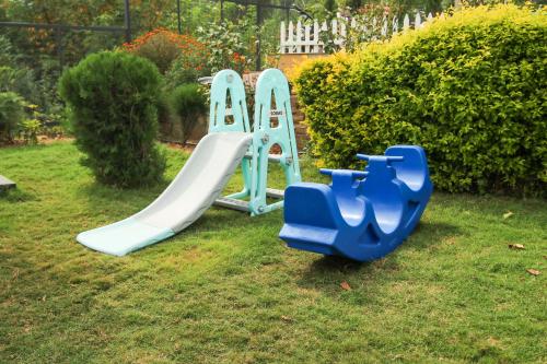 two childrens play equipment in a yard at Kaffberry Cafe & Homestays in Kūd