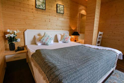 een slaapkamer met een bed in een houten muur bij Kaffberry Cafe & Homestays in Kūd