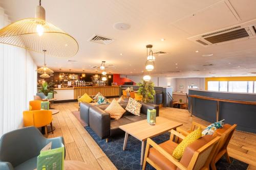 a lobby of a hotel with couches and tables at Holiday Inn Cardiff City Centre by IHG in Cardiff