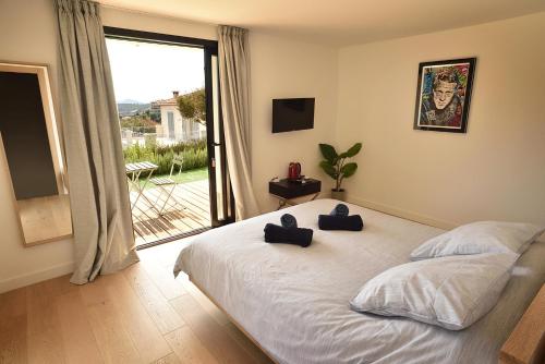a bedroom with a bed with two blue towels on it at La Villa d’Emma in Mougins