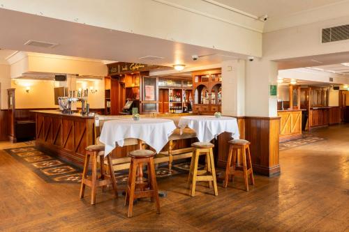 a restaurant with two tables with white table cloth at Holiday Inn Cardiff City Centre by IHG in Cardiff
