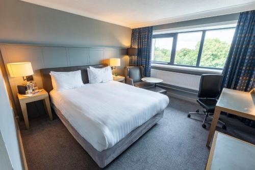 a hotel room with a large bed and a window at Holiday Inn Cardiff City Centre by IHG in Cardiff