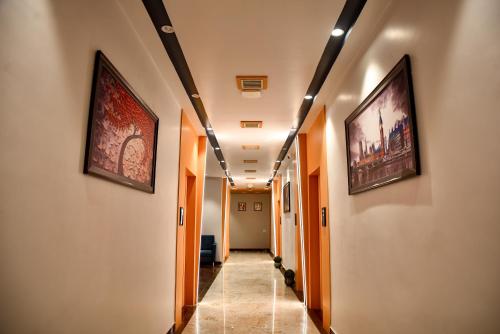 a hallway with paintings on the walls of a building at Grand Savera in Saharsa