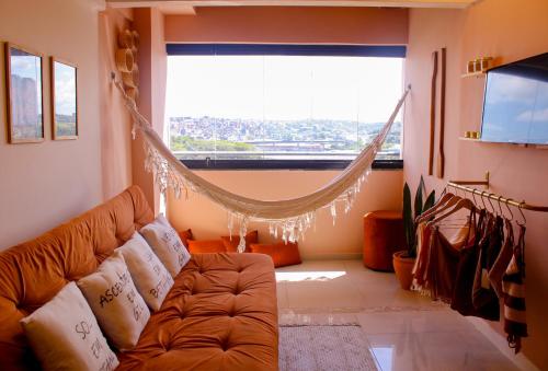 a living room with a couch and a large window at Axé home - Apartamento conceito em Salvador in Salvador