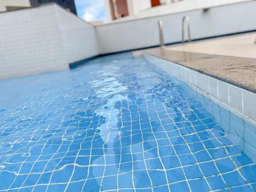 uma piscina com azulejos azuis em cima em Axé home - Apartamento conceito em Salvador em Salvador