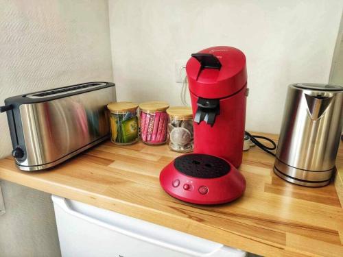 una batidora roja sentada en una encimera de madera en Au p'tit Lagny - rue piétonne, en Lagny