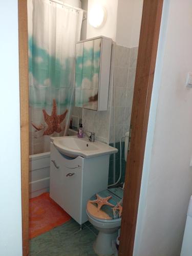 bagno con servizi igienici, lavandino e specchio di Mari a Focşani