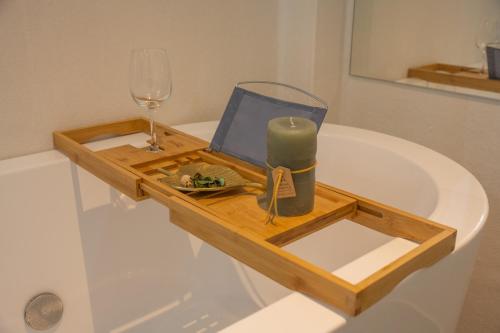 un vassoio con una candela e un bicchiere di vino su una vasca da bagno di サクラシャドウ中目黒 a Tokyo
