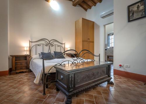 Un dormitorio con una cama y una mesa de madera. en Podere Fossaccio Casa Pino, en Asciano