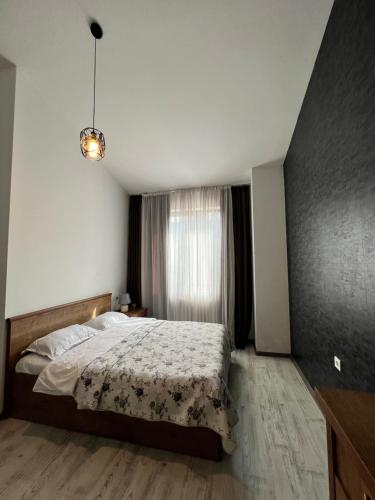 a bedroom with a large bed and a window at Guest House PIROSMANI in Tsqnetʼi
