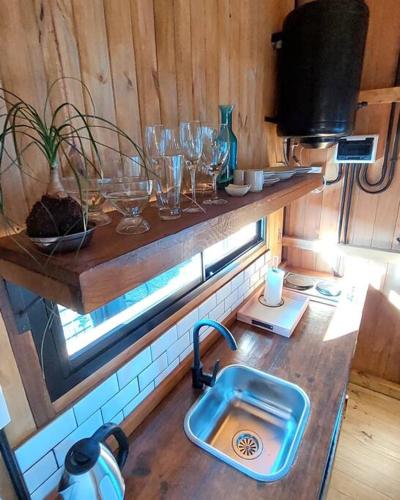 een keuken met een wastafel en glazen op een aanrecht bij Aerohouse in Posadas