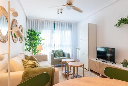 a living room with a couch and a tv at Apartamentos Rocamar in Cangas de Onís