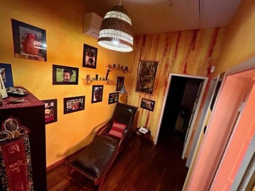 a room with a chair and pictures on the wall at B&B La Casa del Barbiere in Modena