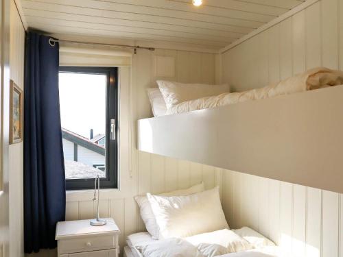 Cette chambre comprend 2 lits superposés et une fenêtre. dans l'établissement Holiday home Søndeled, à Søndeled