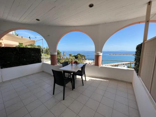 a balcony with a table and chairs and the ocean at Harbour View - Oceanis Apartments in Poros