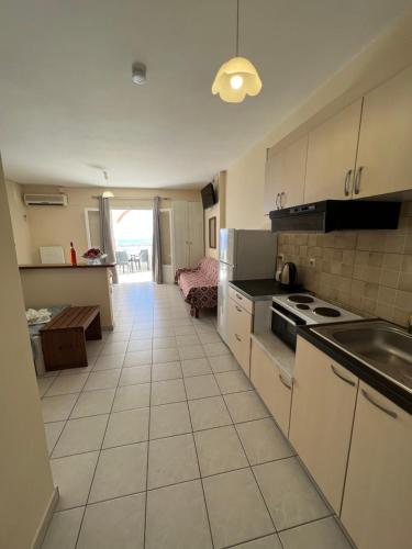 a kitchen with a sink and a stove top oven at Harbour View - Oceanis Apartments in Poros