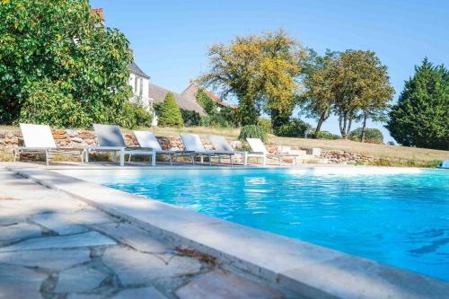 einen Pool mit Liegestühlen neben einem Haus in der Unterkunft Le Domaine du Pavillon • L'idyllique en Brenne in Nuret-le-Ferron