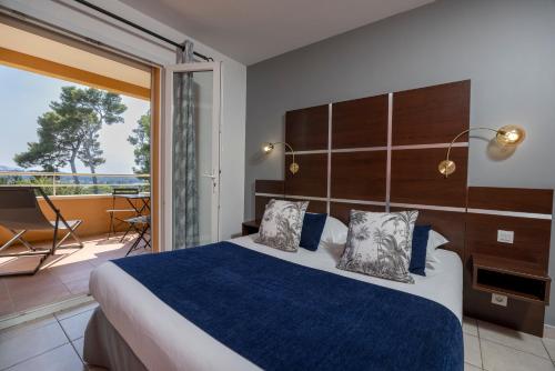 a bedroom with a large bed and a balcony at The Originals City, Hôtel Côté Sud, Marseille Est in Allauch