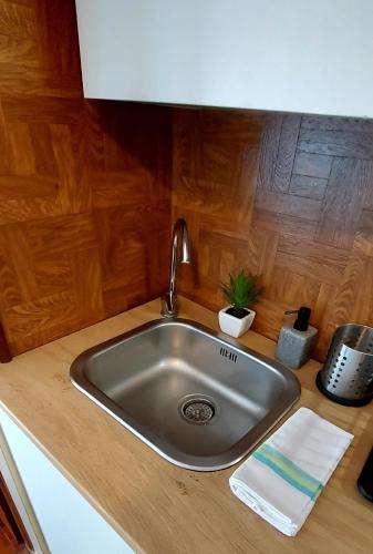un fregadero de acero inoxidable en una cocina con paredes de madera en La Casa del Sole en Carpi
